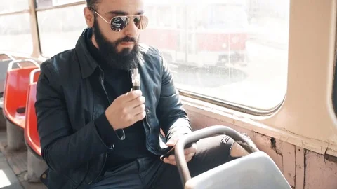 Guy smokes electronic cigarette in a tram Stock Footage 74143295