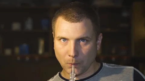 The guy smokes a hookah and exhales smoke into the camera Vídeo Stock 108500975
