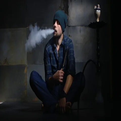 Guy smokes hookah and let smoke rings Vídeo Stock 69460790