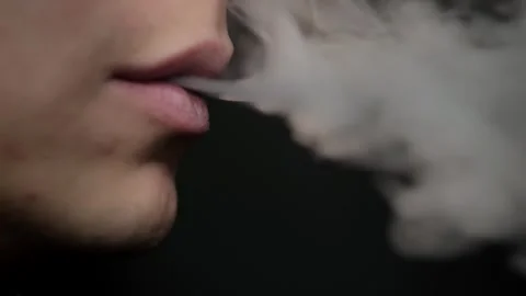 The guy smokes a vape. Close up on a black background. Nicotine addiction 스톡 동영상 295777112