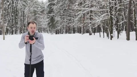 A guy in a snow-covered forest shoots a video Stock-Footage 85093104