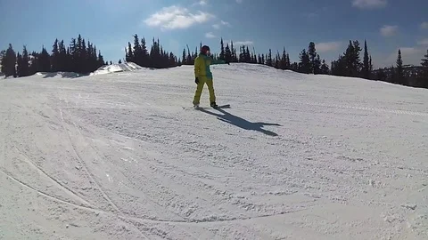 Guy on a snowboard sliding down the slope at sunny day Vidéo 74629721