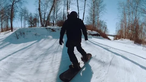The guy is a snowboarder riding down the mountain Stock Footage 241589961