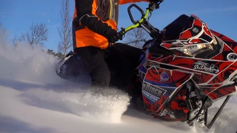 The guy on the snowmobile makes a beautiful turn exposing his leg furrowing snow Video stock 102450786