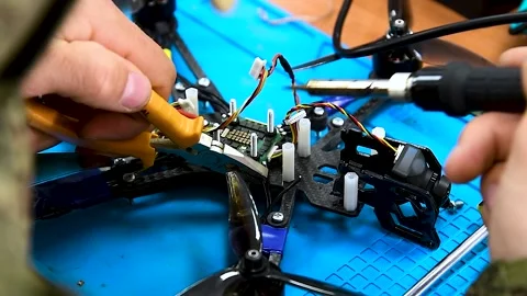 Guy soldering drone FPV wires Video stock 306548662