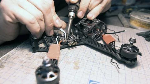 The guy solders the FPV chips of the drone. Front frame view Stock Photos