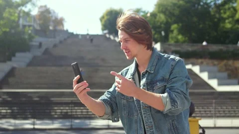 Guy speaks by video call. background of a large staircase Stock-Footage 163364300