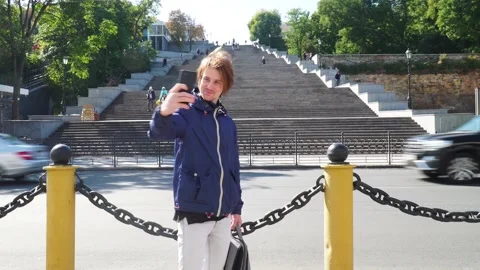 Guy speaks by video call. background of a large staircase 動画素材 163364367