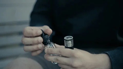 Guy spews liquid in a vape Vídeo Stock 85599817