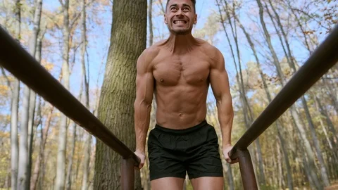 Guy With Sporty Figure Pulls Up On The Beams In The Park. Vídeo Stock 121006427
