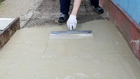 Guy spreads the cement with a wide spatula 库存影片 80291224