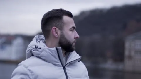 The guy is standing. The guy looks around. Guy in a white jacket Stock Footage 130743328