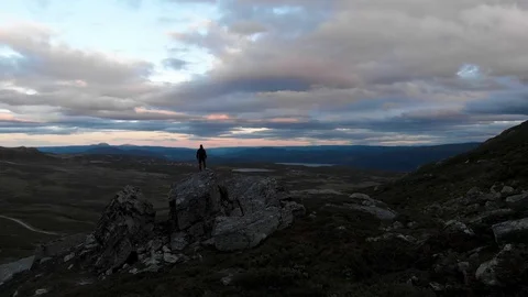 Guy Standing on Mountain hill looking towards horizon. Stockbeeldmateriaal 98798948