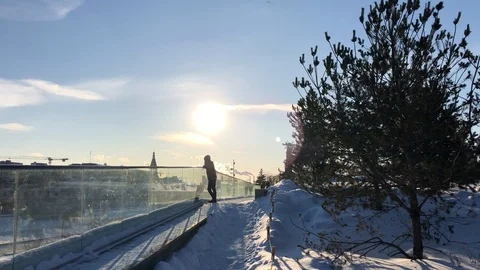 The guy is standing in the park on the background of the sun in the winter in th 스톡 동영상 86700175