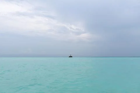 A guy is standing on a rock in the middle of the ocean. The power of the ocea Foto stock