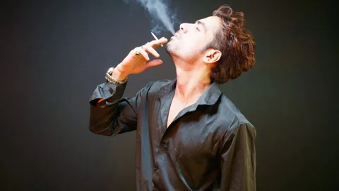 Guy standing smokes quietly appears lost in thought Stock Footage 298243864