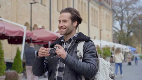 Guy standing at the street and taking pictures on the photocamera.  Video stock 163606231