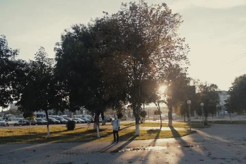 The guy is standing under a tree at sunset Stock Photos