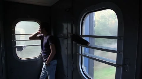 The guy standing in the vestibule of the train and looking out the window Stock Footage 46268274