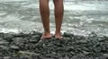 A guy standing on a volcanic stone beach HD Footage