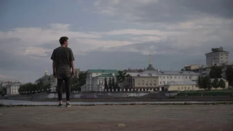 The guy is standing on the waterfront Stockbeeldmateriaal 81142493