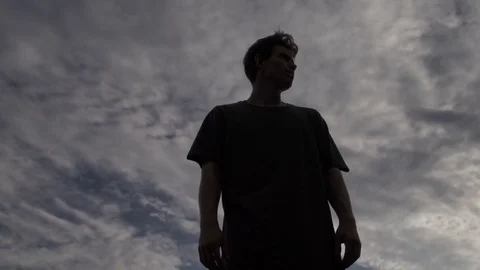 The guy stands against the background of the evening sky 库存影片 81143649