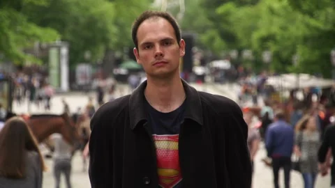A guy stands against the background of people passing by in slow motion Stock Footage 337427077