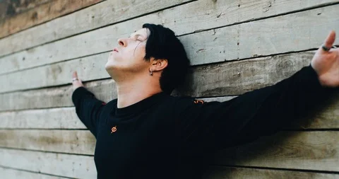 The guy stands against the wall with his arms outstretched. Emotional footage. Stock Footage 114519390