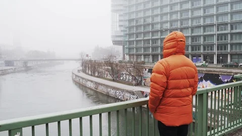 The guy stands on the bridge and looks at the city in the fog Stock Footage 105684225
