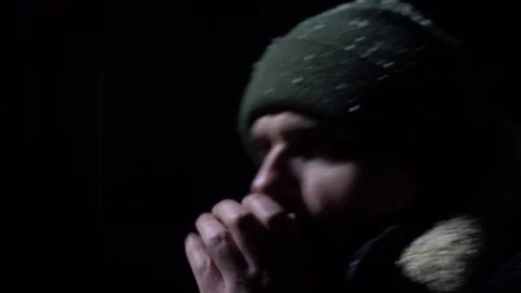 The guy stands in the cold at night and warms his hands. Rubs his nose Stock Footage 122237348