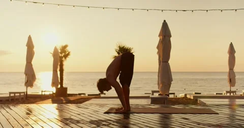 The guy stands up on his hands during a yoga and meditation class on a sunny Video stock 249844322