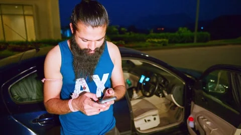 Guy stands outside checking his phone nighttime Stock Footage 305365898