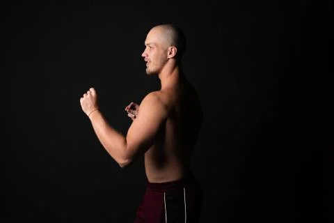 The guy stands sideways in the battle rack on the waist naked pumped healthy Foto stock