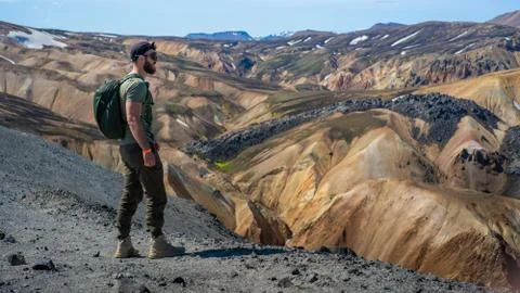 The guy stands on top of the mountain and looks into the distance Stock Photos