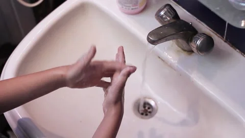 Guy started washing his hands in the bathroom in a white washbasin Stock Footage 201615370