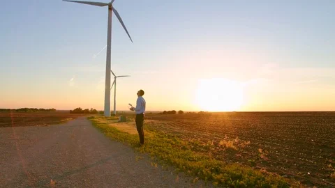 The guy starts the drone against the background of the windmills. Video stock 76691378