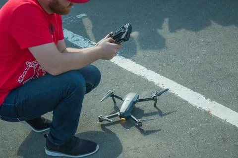 Guy starts a quadrocopter with an asphalt surface Stock Photos