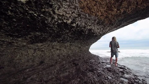 Guy is staying on the rock and looking on the ocean. Video stock 82147446