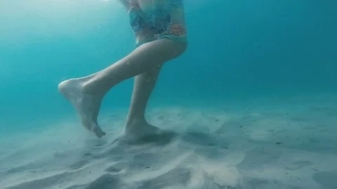 Guy steps on the sand under the water Stock Footage 80535445