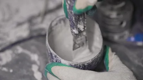 The guy is stirring the building mixture. Close-up. Stockbeeldmateriaal 147077391