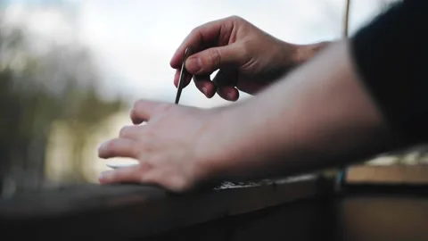 The guy is stirring coffee with a spoon while standing on the balcony Stock Footage 228419204