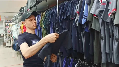 The guy in the store examines clothes Stock Footage 194519056