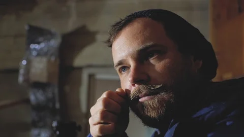 The guy straightens his mustache. a man with a beard and mustache puts himsel Stock Footage 102768378