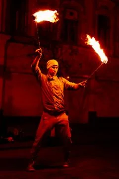The guy on the street performs with fire torches Stock Photos