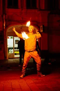 The guy on the street performs with fire torches Stock Photos