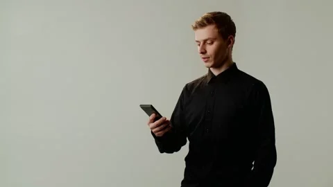 A guy student within serious look uses a smartphone for reading eBooks away Stock Footage 253035878