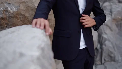 Guy in a stylish suit poses in the mountains. 動画素材 305589071