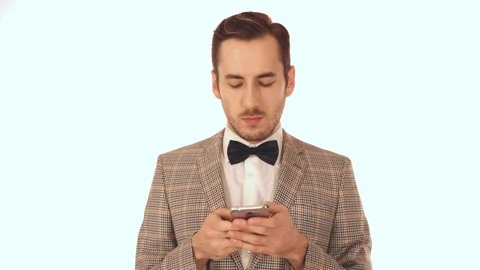 The guy in the suit with the butterfly writes a message on the phone Video stock 72035107