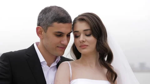 Guy in suit hugs bride with long hair under fluffy veil Video stock 131045879