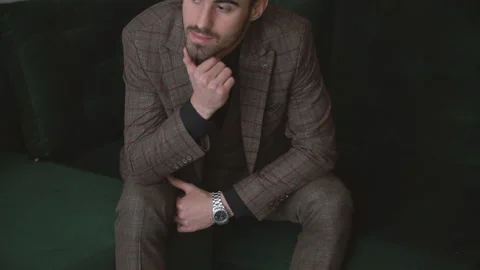 Guy in a suit sitting on the couch Video stock 143861593